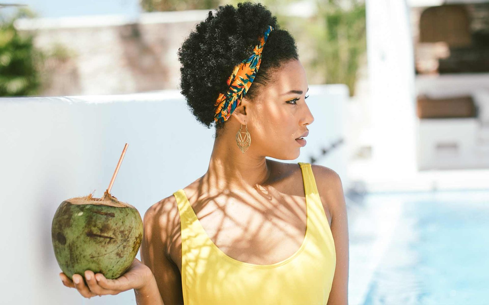 Stunning girl relaxing by the rooftop pool with fresh coconut juice at a Cartagena retreat held at the Amarla Boutique Hotel