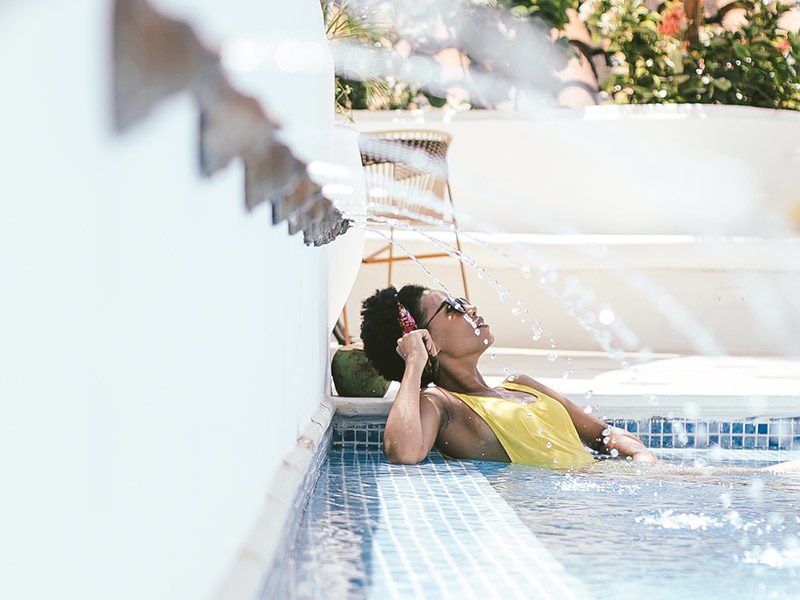 Stunning girl relaxing by the rooftop pool with fresh coconut juice at a Cartagena retreat held at the Amarla Boutique Hotel