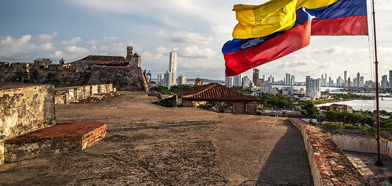 Colombian flag flying in the wind on the walls of the fort in Cartagena Walled City in Colombia